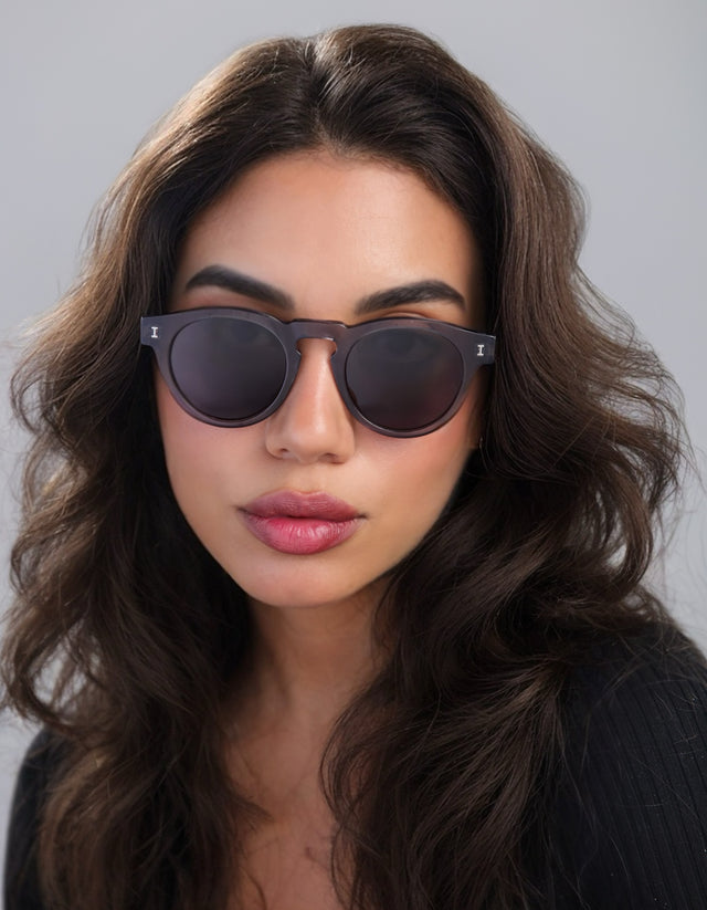 Woman with brown curly hair wearing Leonard Sunglasses in Mercury with Grey