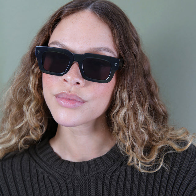 Brunette model with ombré wavy hair wearing Lewis 50 Sunglasses Pine with Grey Flat