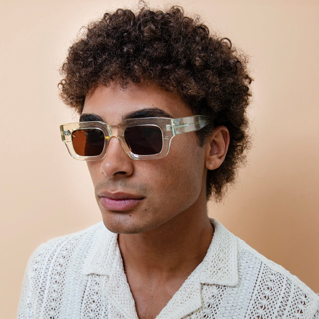 Model with afro-curly hair wearing Lewis Sunglasses Champagne with Brown Flat