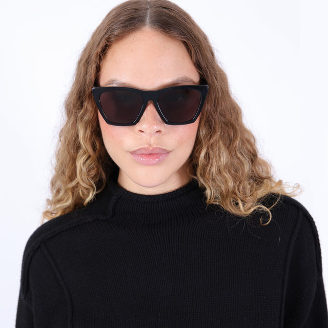 Brunette model with ombre, natural curls wearing Lisbon Sunglasses Black with Grey