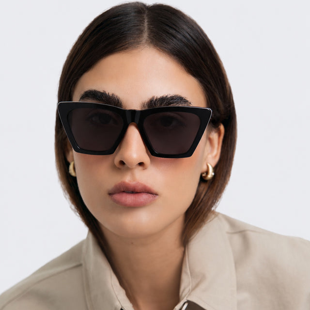Woman in a trench coat wearing Lisbon Sunglasses Black with Grey