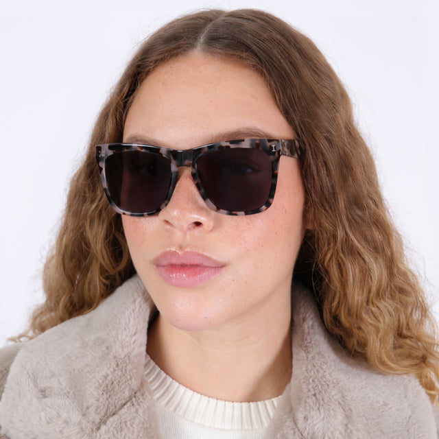 Brunette model with ombré, wavy hair wearing Los Feliz Sunglasses White Tortoise with Grey