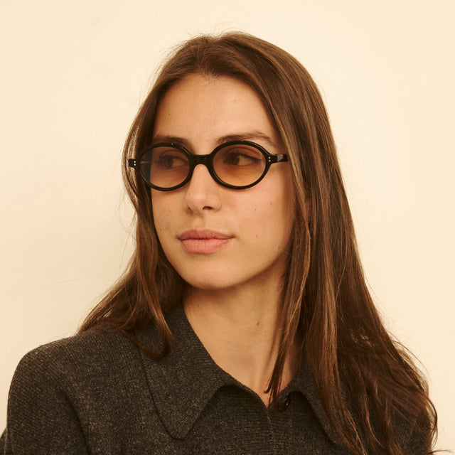Woman in a cashmere blouse wearing Lugano Sunglasses Black with Taupe Flat Gradient