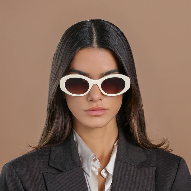 Brunette model looking forward wearing Luna Sunglasses Cream with Brown Flat Gradient