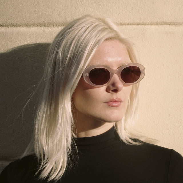 Woman in Paris wearing a black mockneck  wearing Luna Sunglasses Thistle with Brown Flat