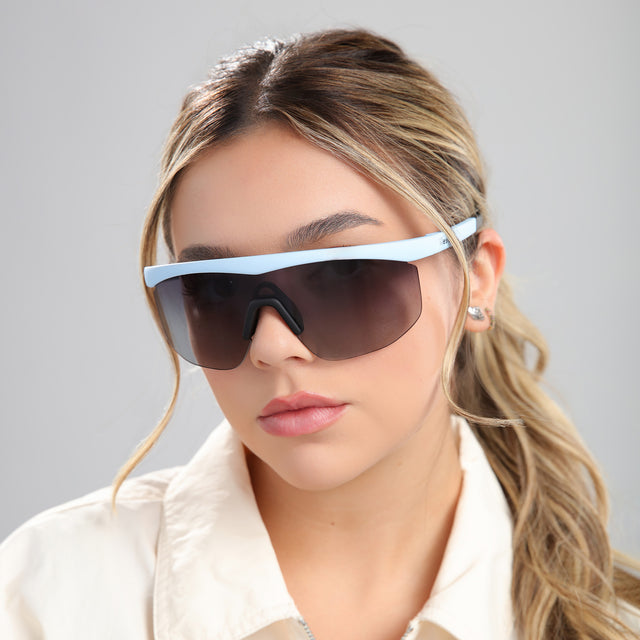 Another angle of blonde woman in a white linen blouse wearing Managua Sunglasses Matte Baby Blue with Grey Gradient