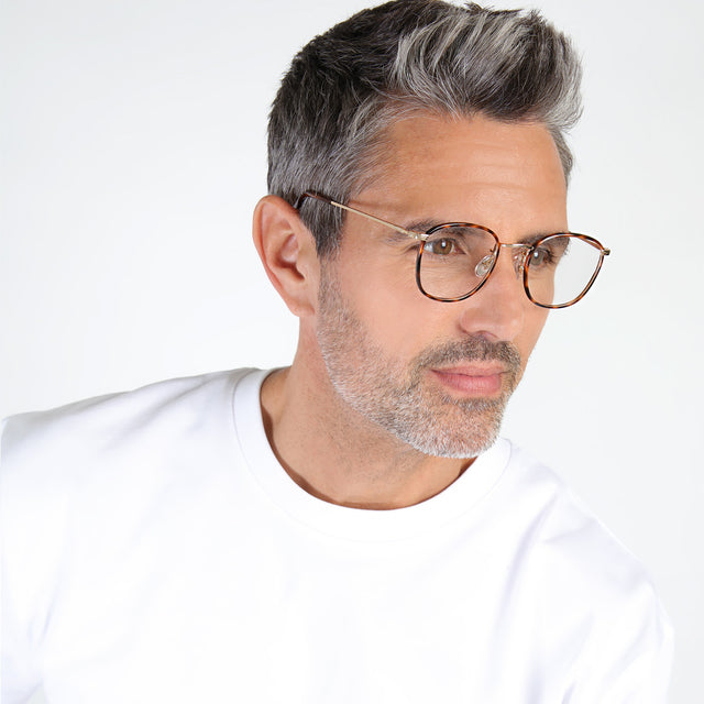 Model with salt and pepper hair and beard looking left wearing Mayfair Optical Havana/Gold Optical