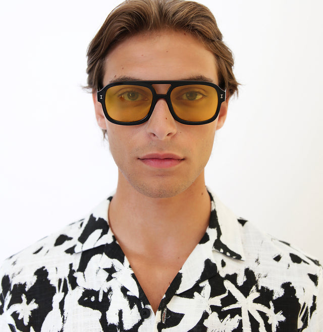 Model with short brown hair lightly combed back wearing Memphis Sunglasses Black with Honey See Through