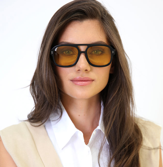 Brunette model with wavy hair wearing Memphis Sunglasses Black with Honey See Through