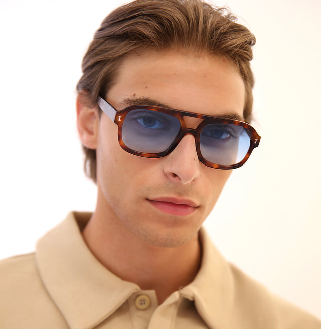 Model with short brown hair lightly combed back wearing Memphis Sunglasses Havana with Blue Gradient See Through
