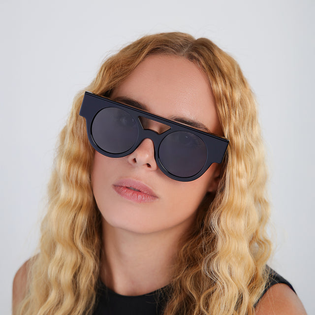 Blond woman with wavy hair wearing Meyer (15 Year Anniversary) Sunglasses Black with Grey Flat