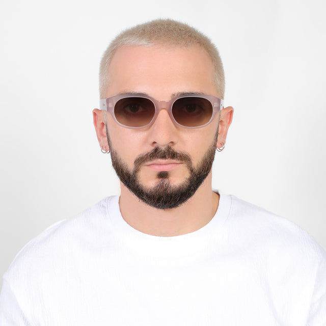 Model with a platinum buzzcut wearing Montreal E Sunglasses Thistle with Brown Flat Gradient