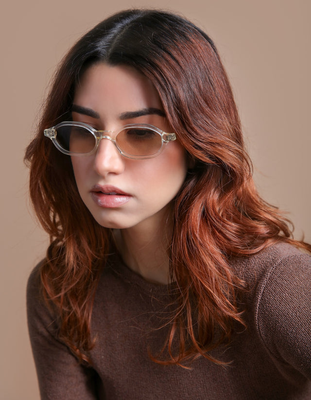 Woman in a brown blouse wearing the Munich Sunglasses in Champagne