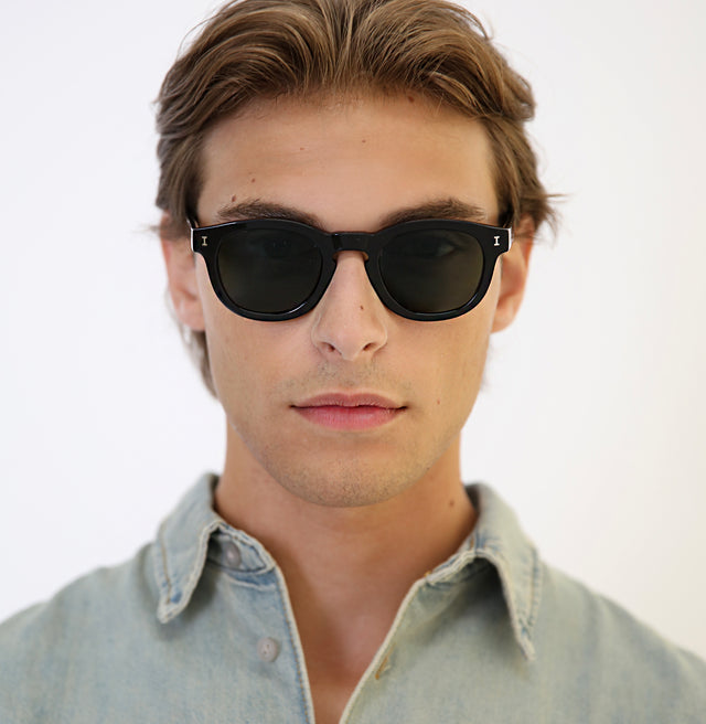 Model with brown hair pushed back wearing Murdoch Sunglasses Black with Olive