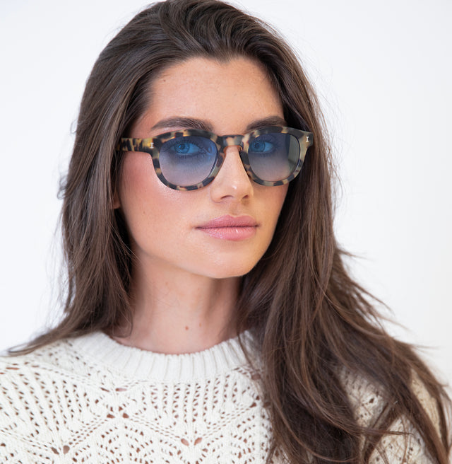 Brunette model with wavy hair wearing Murdoch Sunglasses Matte Tortoise with Blue Gradient See Through