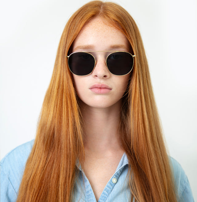 Model with straight red hair wearing Mykonos II Sunglasses Gold with Grey Flat