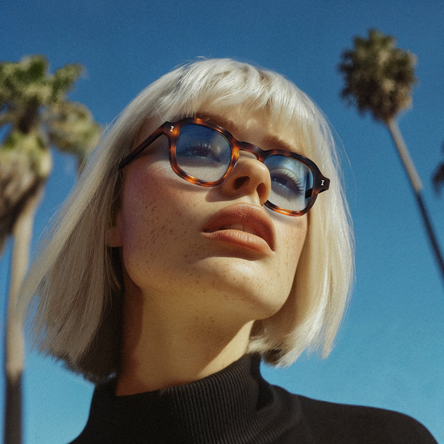 Model near palm trees wearing Washington Sunglasses