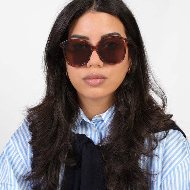 Brunette model in a blue and white striped blouse wearing Nancy 57 Sunglasses Havana with Brown