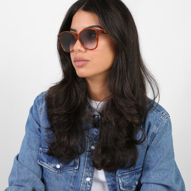 Brunette model in a denim jacket looking right wearing Nancy 57 Sunglasses Red Havana with Grey Gradient