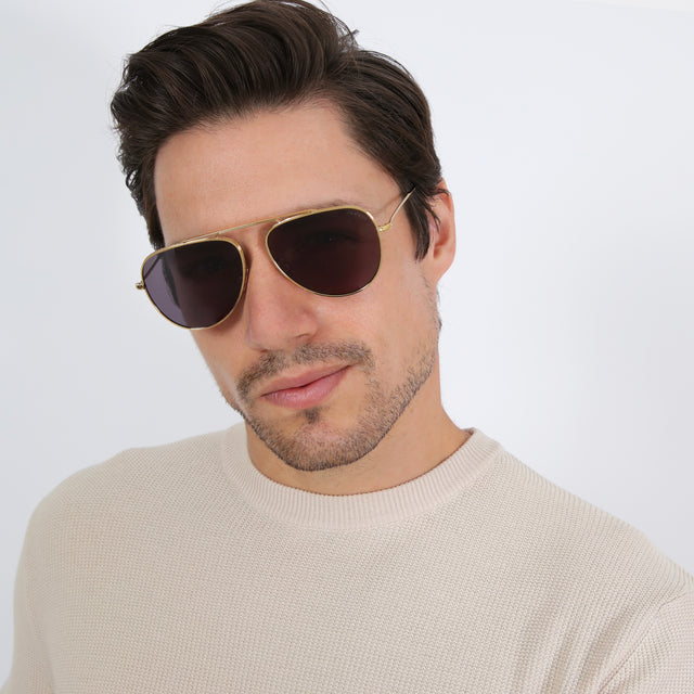 Model with short brown hair in a waffled shirt wearing Naxos 58 Sunglasses Gold with Grey Flat