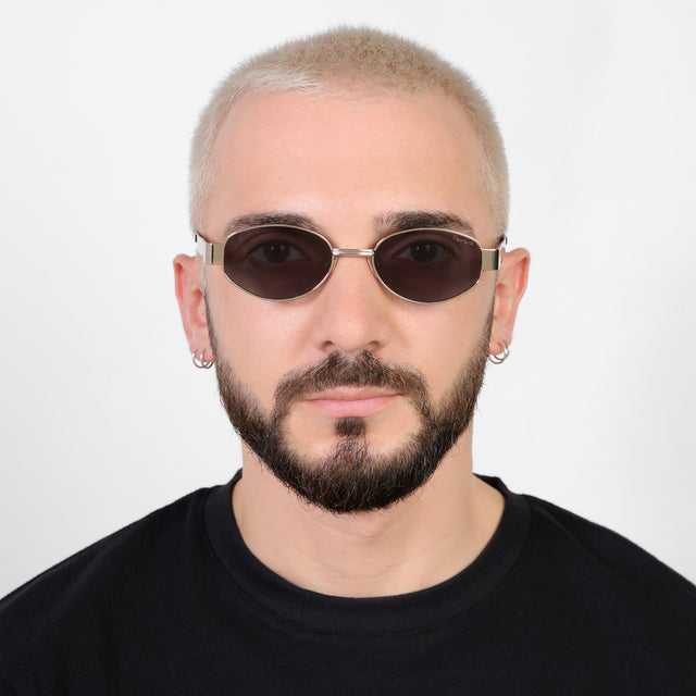 Model with a platinum buzzcut wearing Nesso Sunglasses Gold with Grey