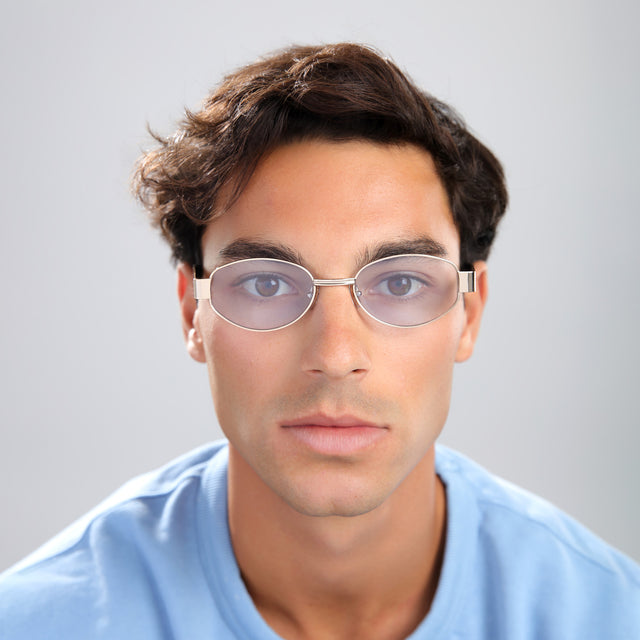 Man with brown hair in a baby blue shirt wearing Nesso Sunglasses Gold with Light Blue See Through