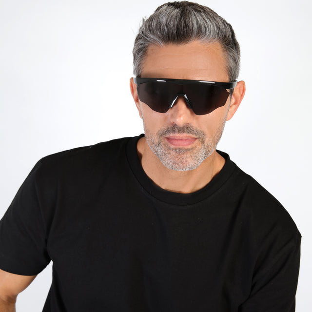 Model with salt and pepper hair and beard wearing Nick Kyrgios x illesteva 1 Sports Frames Black with Grey
