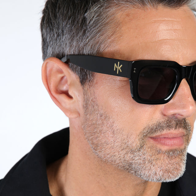 Close up of model with salt and pepper hair and beard wearing Nick Kyrgios x illesteva 2 Sunglasses Black with Grey Flat