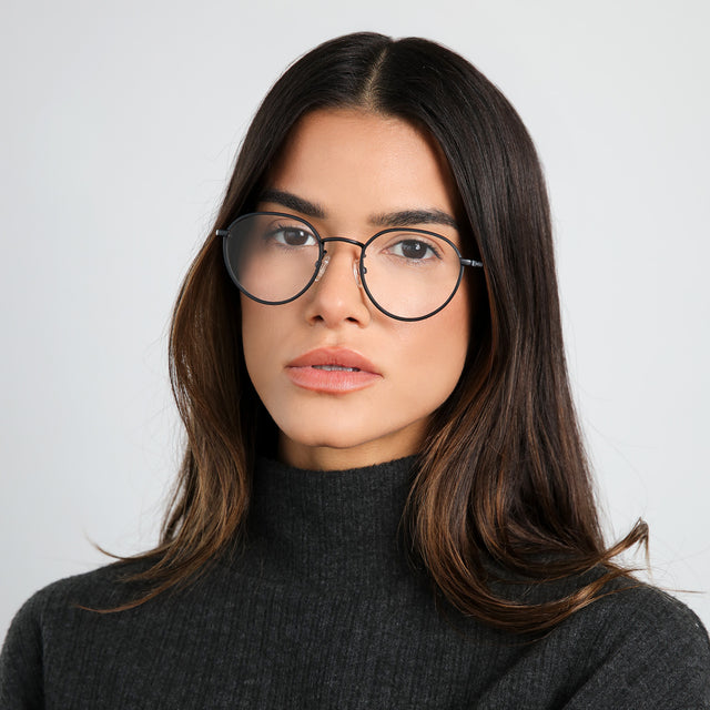 Brunette woman wearing a black cashmere turtleneck wearing Oxford Optical Matte Black Optical