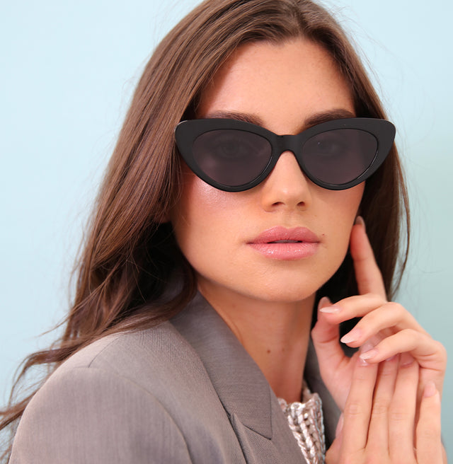 Brunette model with wavy brown hair wearing Pamela Sunglasses Black with Grey Flat