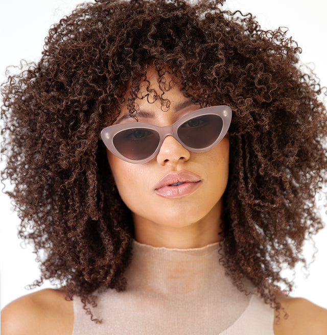Brunette model with afro-curly hair wearing Pamela Sunglasses Thistle with Brown Flat