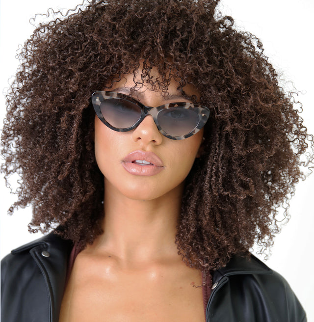 Model with curly hair wearing Pamela Sunglasses White Tortoise with Grey Flat Gradient