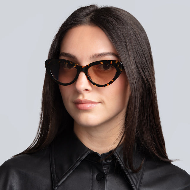 Woman in a leather blouse wearing Pamela Sunglasses Flame with Taupe Flat Gradient