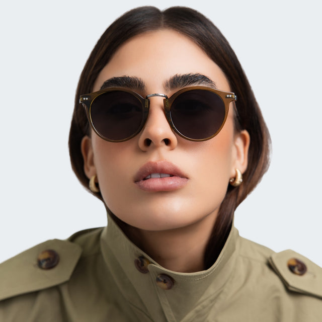 Another angle of woman in a trench coat wearing Portofino Sunglasses Moss with Grey Gradient