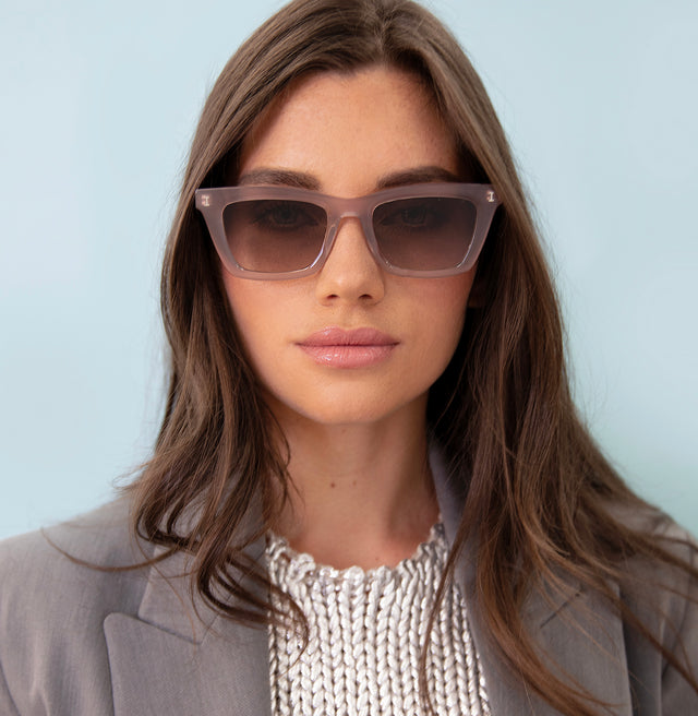 Brunette model with straight hair in a blazer wearing Portugal Sunglasses Thistle with Brown Flat Gradient