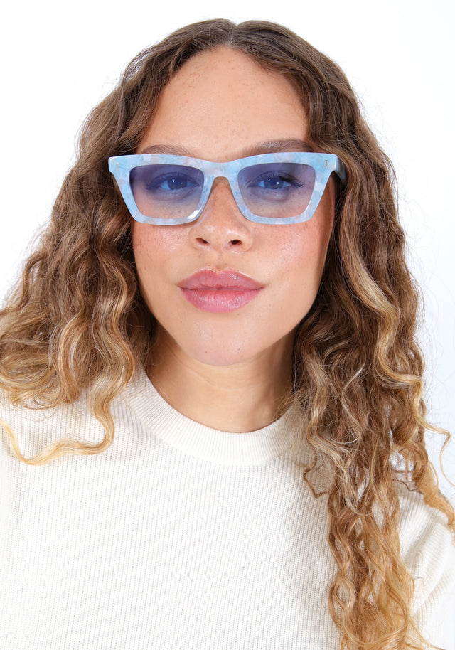 Brunette model with ombre hair wearing Portugal Sunglasses in Celeste with Blue Gradient See Through