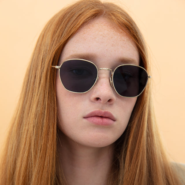 Model with straight red hair wearing Prince Sunglasses Rose Gold with Grey Flat