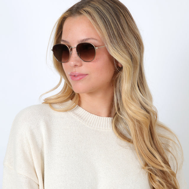 Blonde model with loose curls wearing Prince Sunglasses Rose Gold with Brown Flat Gradient