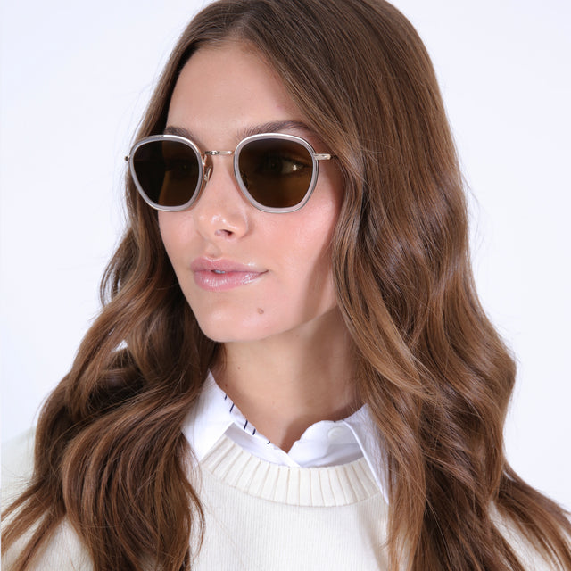 Brunette model with curled hair wearing Prince Tate Sunglasses Matte Clear/Gold with Brown Flat