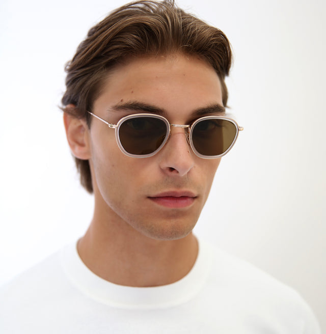 Model with short, brown hair combed back wearing Prince Tate Sunglasses Matte Clear/Gold with Brown Flat