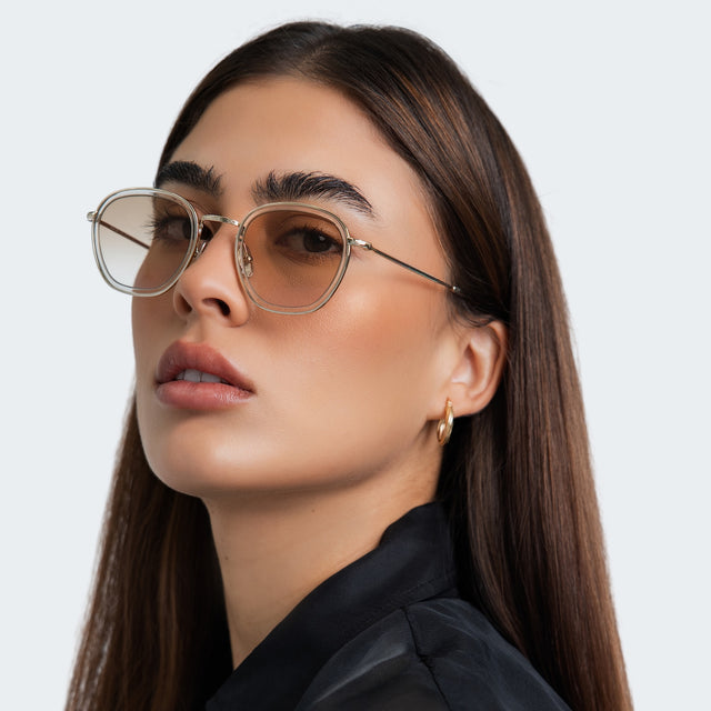 Another angle of woman in a black blouse wearing Prince Tate Sunglasses Champagne/Gold with Taupe Flat Gradient