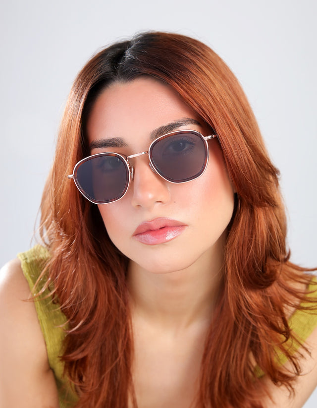 Woman in a chartrieusse blouse wearing Prince Tate Sunglasses in Havana