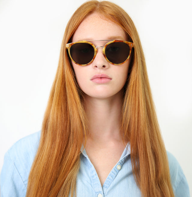 Model with straight red hair wearing Puglia Sunglasses Amber/Rose Gold with Grey Flat