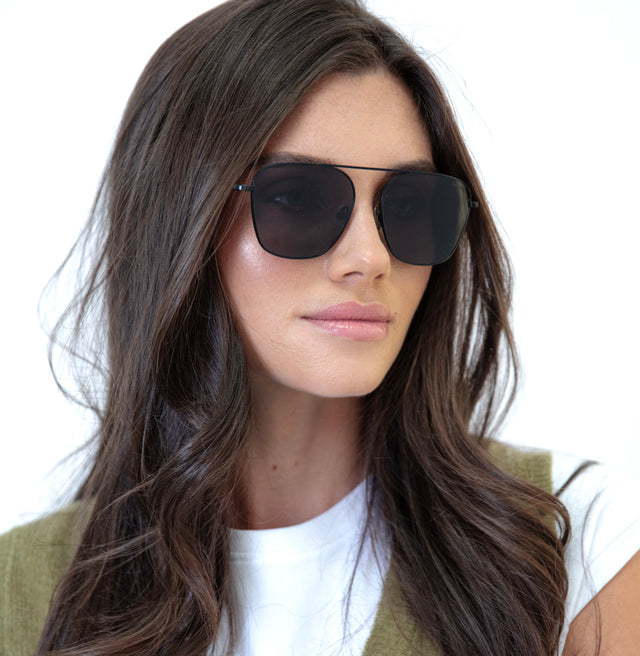 Brunette model with wavy hair Samos Sunglasses Side Profile in Black / Grey Flat