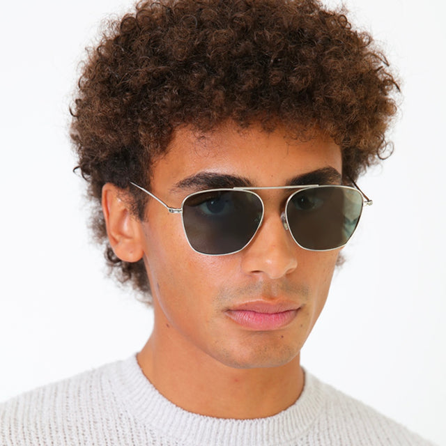 Model with afro-curly hair wearing Samos Sunglasses Silver with Olive Flat