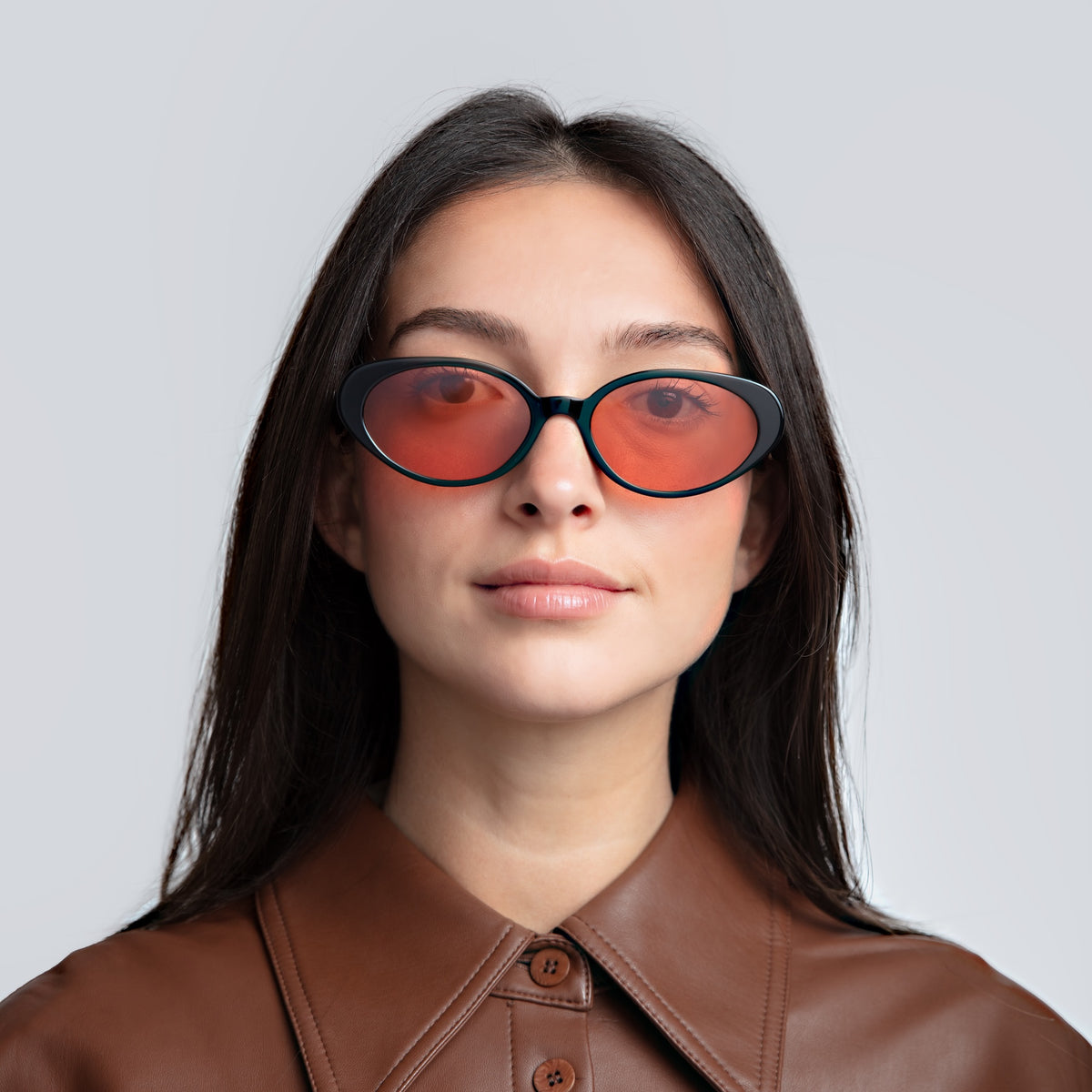 Woman wearing Sheila Sunglasses in Black with Sunset Flat lenses, front view, Woman in a brown leather blouse