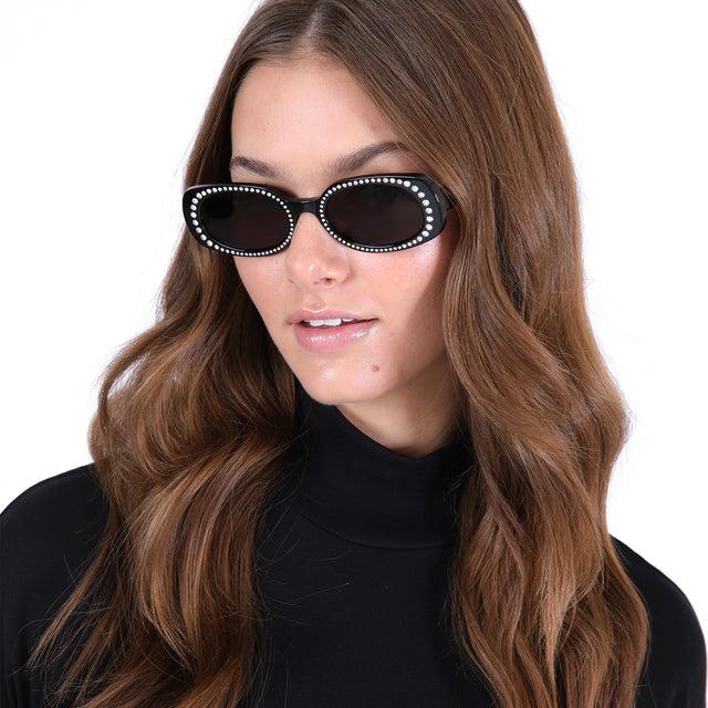 Brunette model with loose curls wearing Shirley Crystal Sunglasses Black w/ Silver Swarovski Crystals with Grey Flat