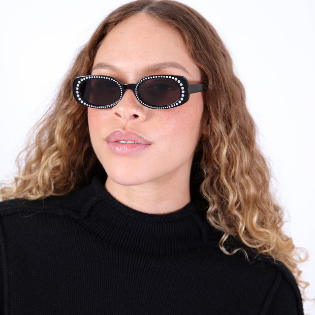 Brunette model with ombré, natural curls wearing Shirley Crystal Sunglasses Black w/ Silver Swarovski Crystals with Grey Flat