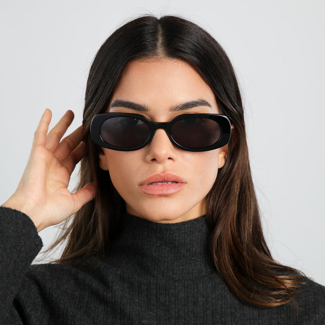 Model in a dark gray knit turtleneck wearing Shirley 51 Sunglasses Black with Grey