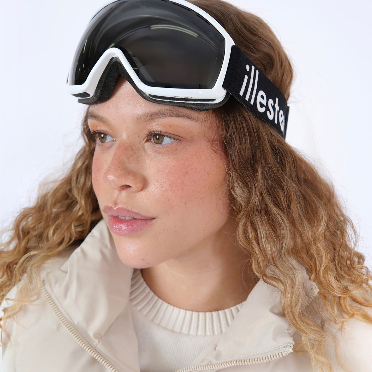 Woman wearing Ski Goggles in Matte Baby Blue Grey Polarized, Brunette model with ombre wavy hair in a puffer jacket